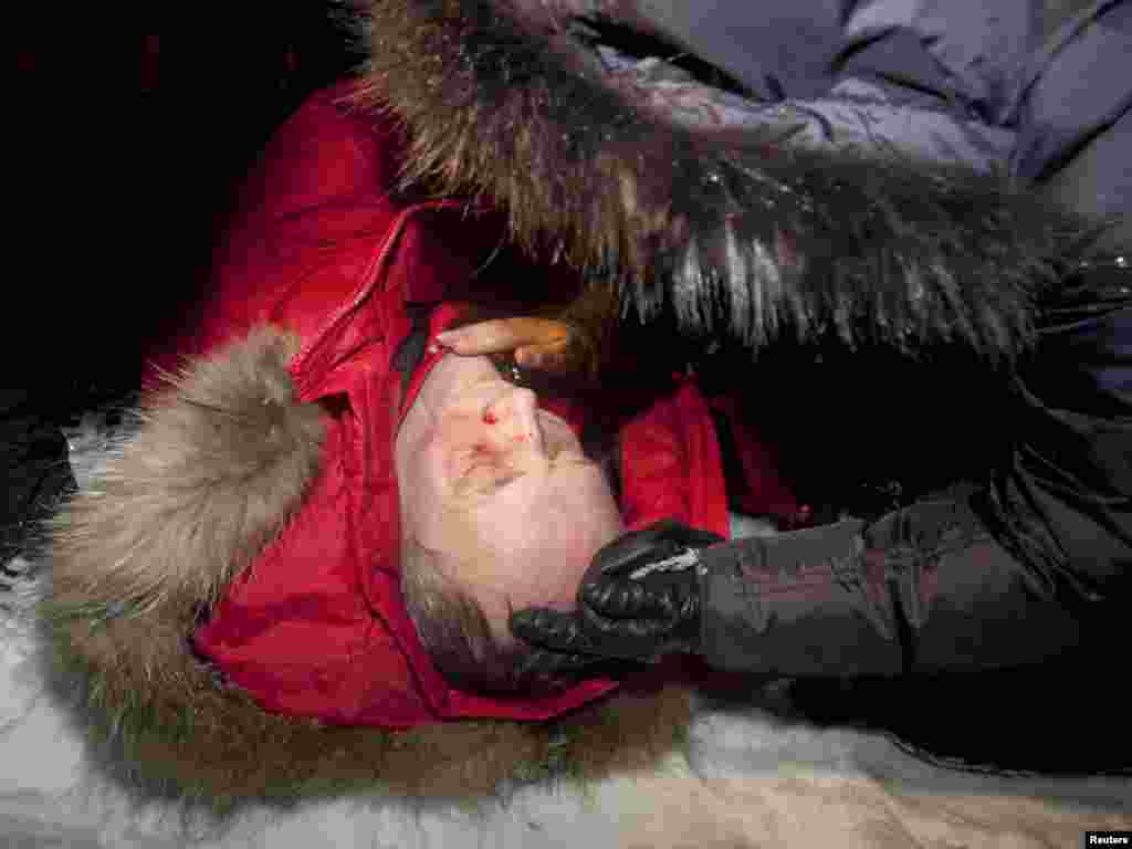 Presidential candidate Uladzimir Nyaklyaeu lies on a street after he was beaten during the rally in Minsk.