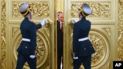 Honor guards open the doors for Russian President Vladimir Putin followed by Crimean leaders entering the hall for the signing ceremony of a treaty for Crimea to join Russia in the Kremlin in March 2014. 