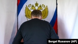  An oil worker marks his ballot in a voting booth in Russia's Tyumen region.