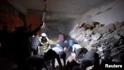 People search for survivors among the rubble of an area damaged by what activists say was a missile attack by the Syrian regime in Raqqa Province in April.