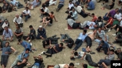 Ethnic Uzbek men rest at a refugee camp on the Kyrgyz side of the border with Uzbekistan on June 20.