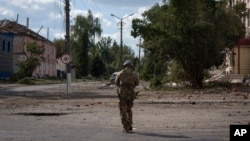 A Ukrainian soldier walks through the center of the town of Sudzha in Russia's Kursk region. 