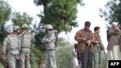 Afghan police and U.S. soldiers inspect the site of a suicide car-bomb attack in Bati Kot district in Nangarhar Province.