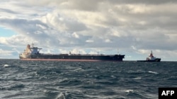 A handout photo released by the German Central Command for Maritime Emergencies on January 10 shows the tanker Eventin as a tugboat attaches a towing line. 