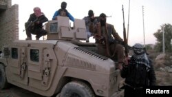 Sunni gunmen sit on top of an Iraqi Army vehicle left by Iraqi soldiers during clashes in the city of Fallujah on January 9.