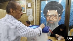 An Iranian casts his ballot in Tehran for elections in 2012 in front of a portrait of Supreme Leader Ayatollah Ali Khamenei.