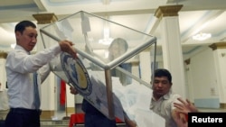 Members of a local electoral commission empty a ballot box at a polling station in Bishkek on June 27.