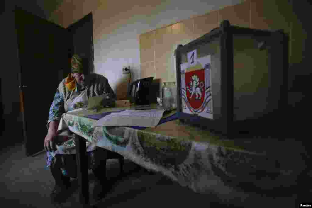 A woman looks at her ballot paper before casting her vote in the village of Pionerskoye.