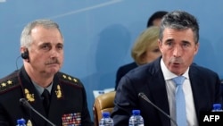 NATO Secretary-General Anders Fogh Rasmussen (right), flanked by acting Ukrainian Defense Minister Mykhaylo Koval, speaks during a defense ministers' meeting at NATO headquarters in Brussels on June 3.