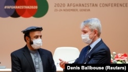 Afghan Economy Minister Abdul Hadi Arghandiwal and Finnish Foreign Minister Pekka Haavisto speak prior to the plenary session of the 2020 Afghanistan Conference at the United Nations in Geneva on November 24.