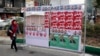 An Iranian woman walks past electoral posters on a street in Tehran.