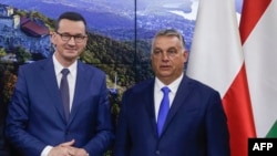 Polish Prime Minister Mateusz Morawiecki (left) and Hungarian Prime Minister Viktor Orban pose ahead of a press conference in Brussels on September 24.