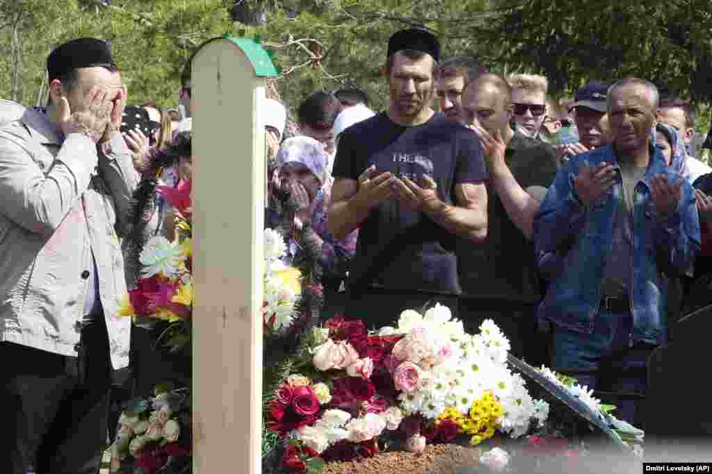 People pray next to Ignatyeva&#39;s grave.