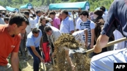 Survivors and relatives of Srebrenica victims bury their dead during a ceremony on July 11