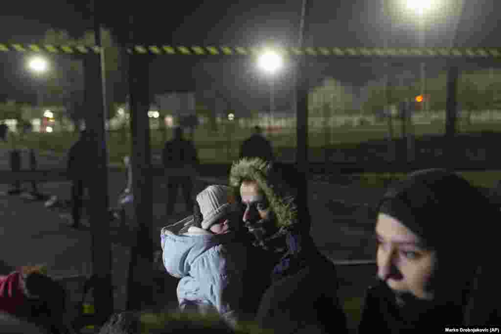 A man holds a child close to the border crossing.&nbsp;A Syrian woman, identified only as Amira, told Reuters the migrants wanted &quot;a better life for our children.&quot;