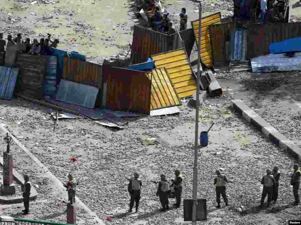 Egyptian soldiers stand in front of barricaded antigovernment protesters outside the Egyptian Museum near Tahrir Square.