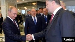 Russian President Vladimir Putin (left) shakes hands with Ukrainian President Petro Poroshenko ahead of talks in Minsk on August 26.