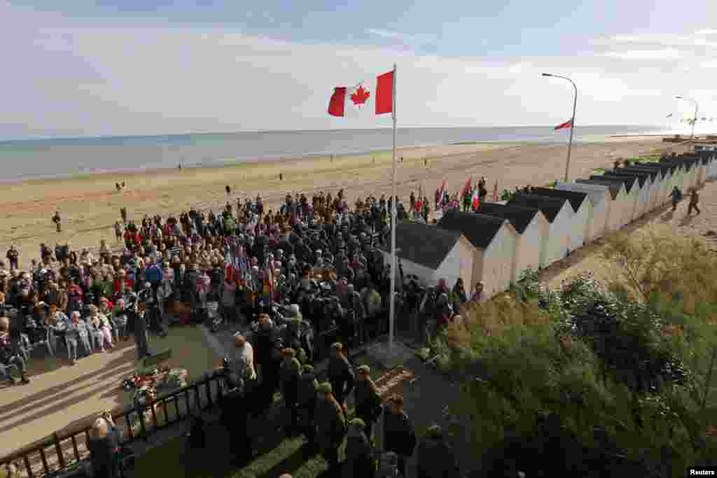 Family members of Canadian D-Day veterans, currently-serving soldiers, and local citizens attend a ceremony outside The Queen&#39;s Own Rifles of Canada House in Bernières-sur-Mer.