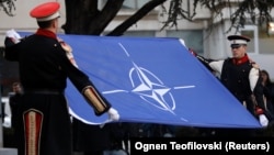 Members of the honor guard raise the NATO flag in front of North Macedonia's parliament to mark the ratification of the country's accession to the military alliance in Skopje on February 11.