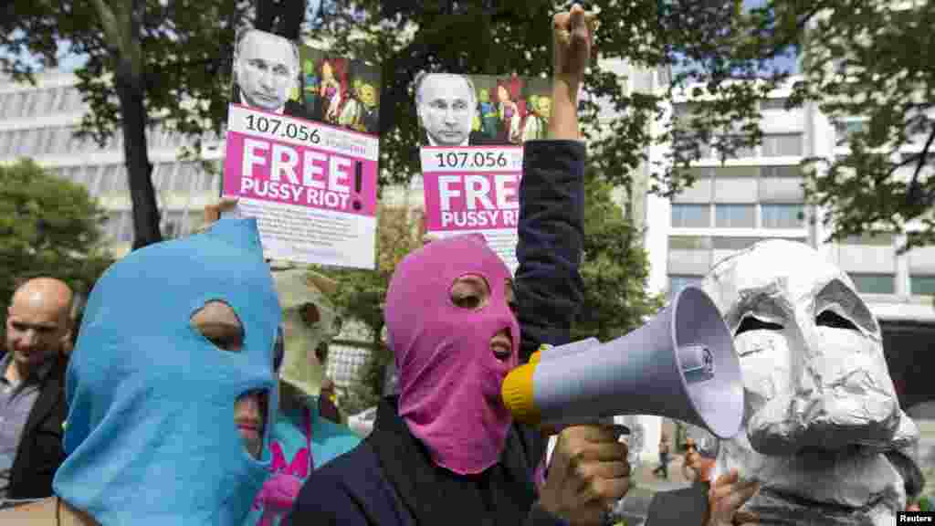 People wear caricature masks of Russian President Vladimir Putin and trademark Pussy Riot balaclavas during a support rally for the detained members outside the Russian Embassy in Berlin on August 17.