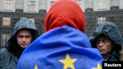 A protester wrapped in a EU flag attends a rally to support EU integration in Kyiv on November 25.