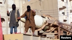 Fighters from the Islamic State group gesture as they take part in a military parade on the streets of Syria's northern Raqqa province in June.