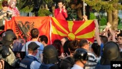 Protesters hold Macedonian and Albanian flags in front of a cordon of special police guarding the government building during an antigovernment protest in Skopje last week.