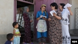 Women discuss the voting before casting their ballot papers at a mobile ballot box in the Uzbek district of Unadir in Osh.