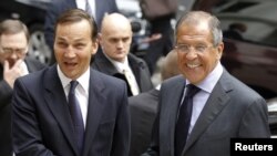 Russian Foreign Minister Sergei Lavrov (right) shakes hands with his Polish counterpart Radoslaw Sikorski at the Foreign Ministry in Warsaw.