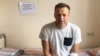 Russian opposition leader Aleksei Navalny sits on a hospital bed in Moscow where he was treated for skin rashes and severe swelling of the face on July 29.