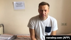 Russian opposition leader Aleksei Navalny sits on a hospital bed in Moscow where he was treated for skin rashes and severe swelling of the face on July 29.