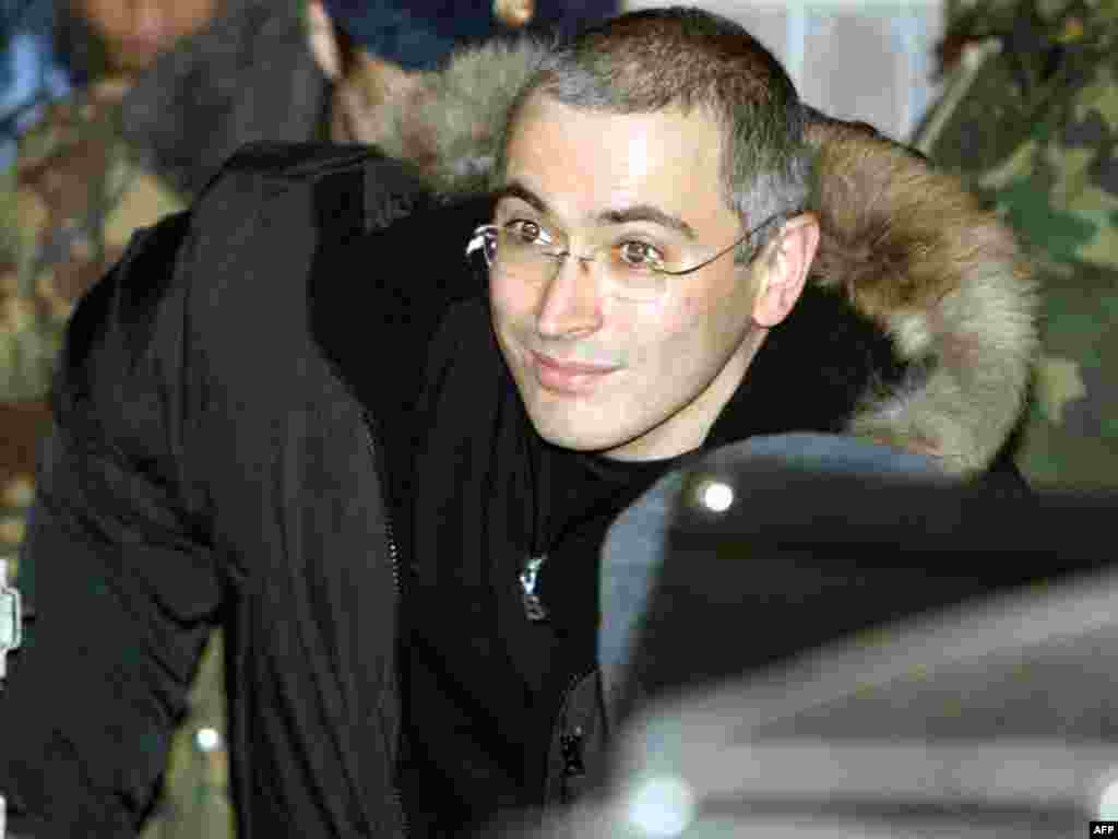 Russian police escort the former Yukos oil chief as he leaves a courthouse in Moscow on December 23, 2003.