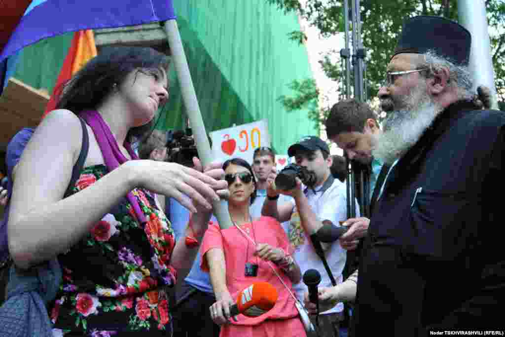 Gay rights activists speak with an Orthodox priest during the International Day Against Homophobia in Tbilisi on May 17.