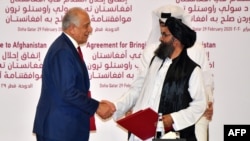 U.S. special envoy Zalmay Khalilzad (left) shakes hands with Taliban co-founder Mullah Abdul Ghani Baradar after signing the peace agreement during a ceremony in the Qatari capital, Doha, on February 29.