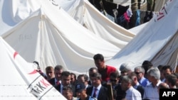 Syrian refugees gather around Turkish Foreign Minister Ahmet Davutoglu (center) during his visit to the Turkish Red Crescent camp in the Yayladagi district of the Turkish city of Hatay on June 15.