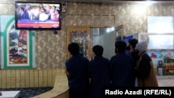 A group of Afghan men follow coverage of Trump's inauguration on TV.