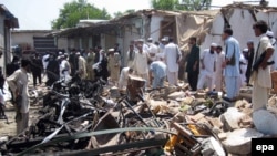 People survey the site of a bomb blast in the Pusht area of Bajaur's Salarzai district in July.