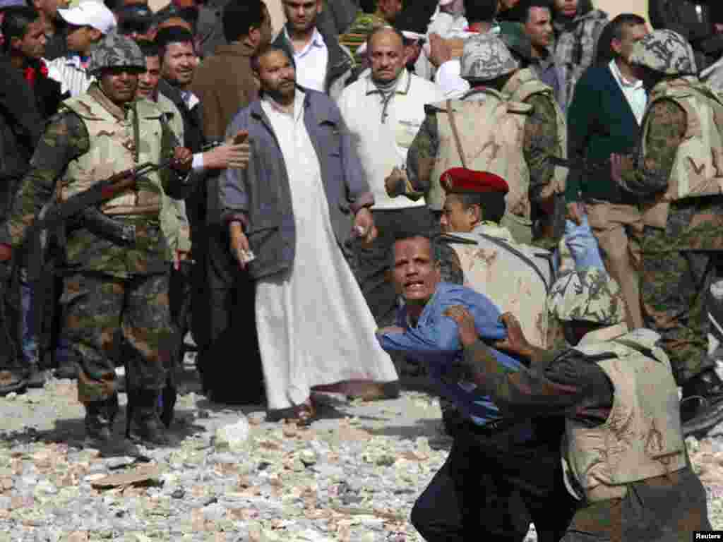 Egypian soldiers restrain a Mubarak supporter trying to get to opposition lines near Tahrir Square.