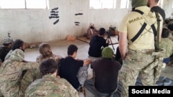 A photo from social media showing Uzbek extremist Abu Ubayda al-Madani (nom de guerre) from the group Liwa al-Muhajireen (Foreign Jihadi Fighters Brigade) lecturing other militants, purportedly before a Hama offensive. 