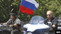 Russian Prime Minister Vladimir Putin (right) rides a Harley Davidson Lehman Trike as he arrives for a meeting with Russian and Ukrainian motorbikers at their camp near Sevastopol on July 24.