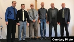 Seventy-one-year-old pastor Yury Korniyenko (seen here third from left with other congregation members) received a court summons and was subsequently charged with engaging in illegal missionary work.