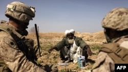 An Afghan farmer chats with a U.S. Marine officer near Marjah.