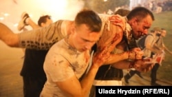 Protesters carry an injured in Minsk late on August 9 following clashes with police following the vote.