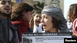 A protester carries a sign referring to Tunisia's ousted president and Egypt's Hosni Mubarak at a demonstration in Beirut. Are such activists reacting to the State Department push for dialogue?