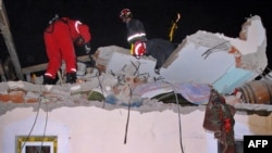 Rescue workers examine the collapsed roof of a building in Kraljevo.