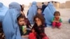 People who were displaced by fighting wait for government assistance at a temporary shelter in Herat Province on July 8.