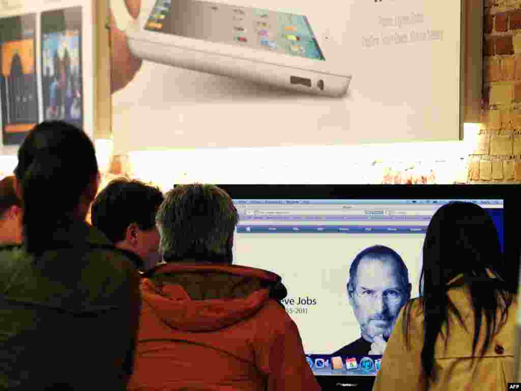 Visitors to an Apple store in Pasadena, California, view a screen from the Apple website announcing Jobs&#39; passing on October 5.