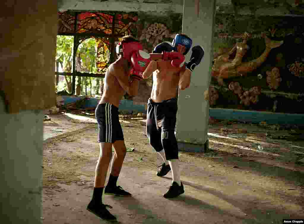 Boxing trainer Lizbar Jalogua spars with a young student in a ruined Soviet-era resort in Gagra.