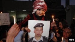 A Jordanian girl holds a picture of Jordanian pilot Muath al-Kasasbeh during a prayer vigil in Amman on February 2.