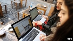 Two Turkish women try to connect to Twitter from their laptops at a cafe in Istanbul on March 21.